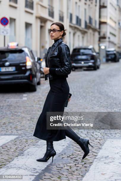 Irina Shayk is seen wearing black vinyl jacket, skirt, boots, sunglasses during a street style shoot as part of Paris Fashion Week on September 27,...