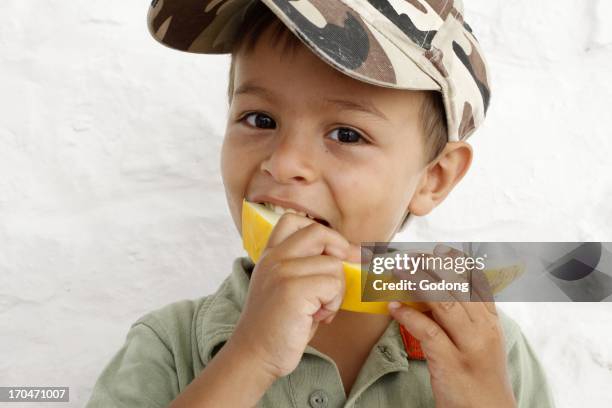 Young boy eating melon, Italy.