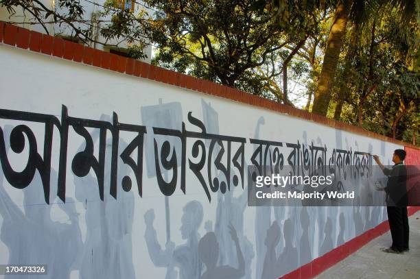 Students from the Fine Arts Institute of Dhaka University paint on a wall in front of the Central Shahid Minar, a monument for the martyrs of the...