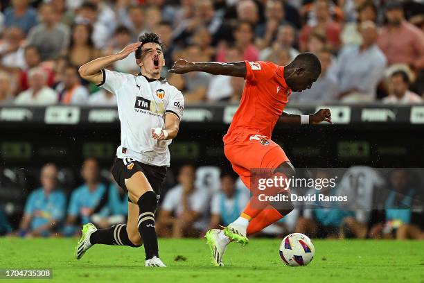 Hamari Traore of Real Sociedad fouls Diego Lopez Noguerol of Valencia leading to a yellow card during the LaLiga EA Sports match between Valencia CF...