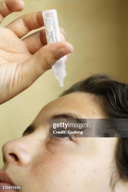 Boy putting eye-drops, Italy.