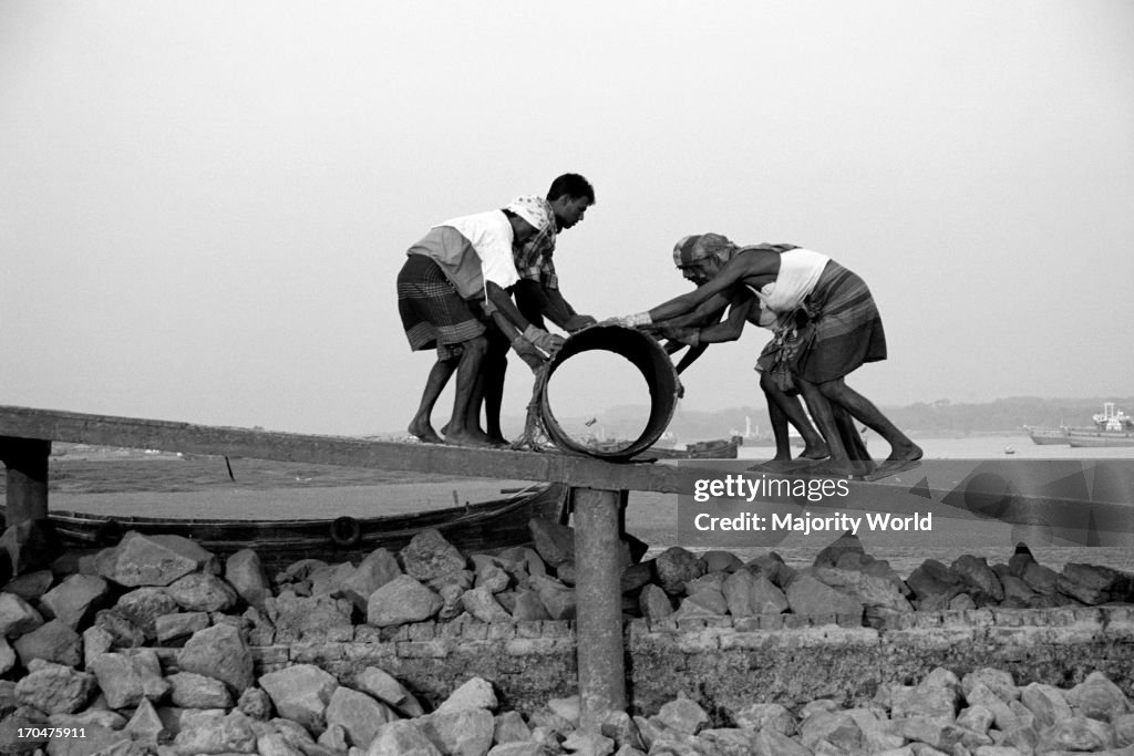 Laborers working at a landing or ghat, on the bank of Karnaphuli