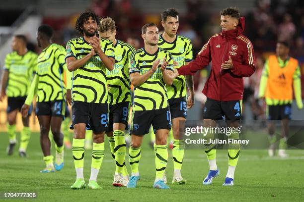 Mohamed Elneny, Cedric Soares and team mates of Arsenal applaud fans following the Carabao Cup Third Round match between Brentford and Arsenal at...