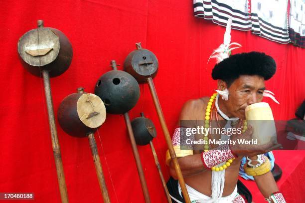 Hornbill Festival of Nagaland-India. A man from the ethnic Angami community drinking from wooden glass on the Hornibill festival at the village of...