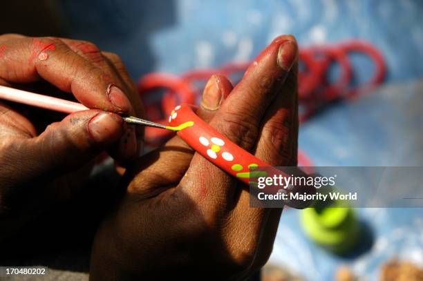 Potter paints a mud bangle to sell it on the Baishakhi Mela which begins on the Bangla New Years day also known as Pahela Baishakh. Dhaka,...