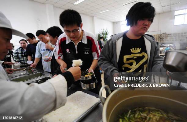 By Marianne Barriaux Patients wait in line for food during lunch hour at a weight reduction clinic in Tianjin on November 18, 2008 in northern China,...