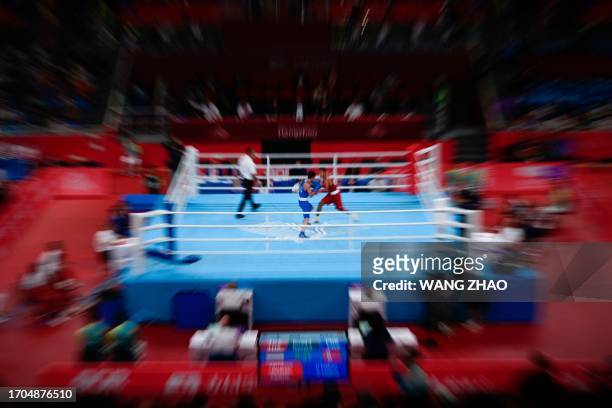 This picture taken with a zoom burst tecnique shows the men's 51-57 kg quarterfinal boxing event during the 2022 Asian Games in Hangzhou in China's...