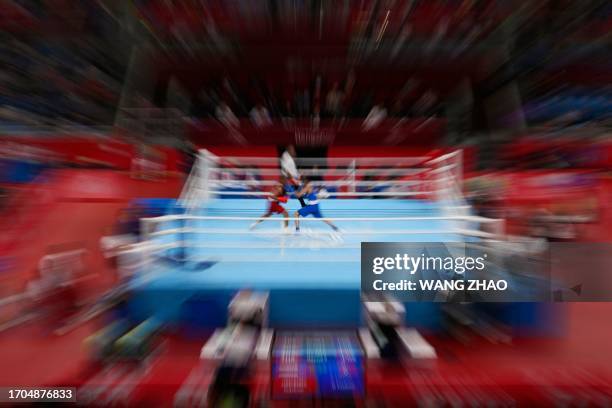 This picture taken with a zoom burst tecnique shows the men's 51-57 kg quarterfinal boxing event during the 2022 Asian Games in Hangzhou in China's...