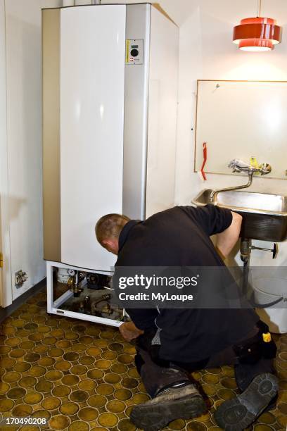 Heating and santiary technician connecting a solar boiler tank.