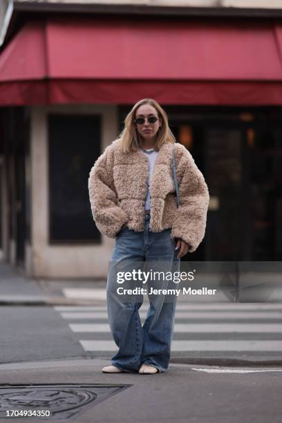 Sonia Lyson is seen wearing sunglasses with golden frame from Celine, a twisted silver necklace from Zara, a fluffy beige jacket from Stand Studio,...