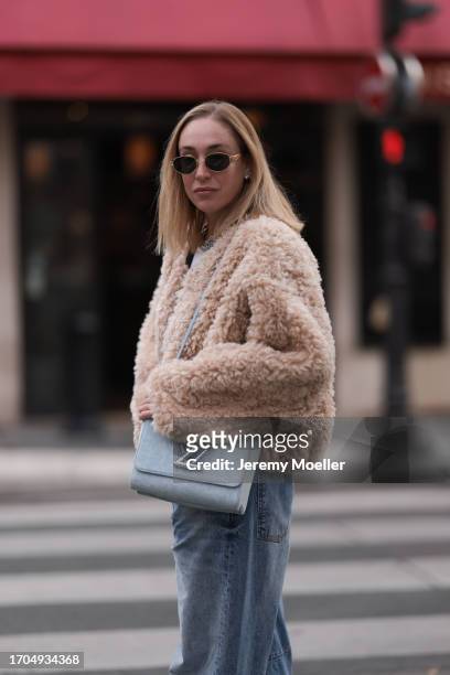 Sonia Lyson is seen wearing sunglasses with golden frame from Celine, a twisted silver necklace from Zara, a fluffy beige jacket from Stand Studio,...