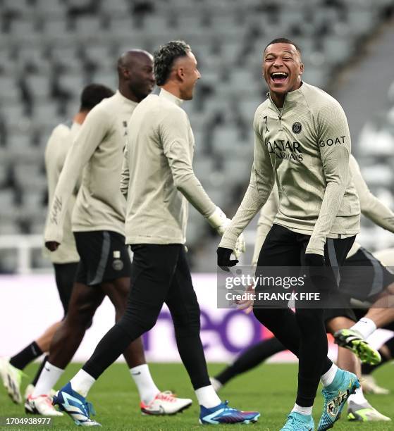 Paris Saint-Germain's French forward Kylian Mbappe jokes during a team training session at St James's Park stadium in Newcastle-upon-Tyne, north east...