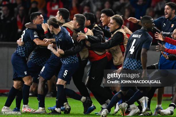 Sporting Braga's Portuguese midfielder Castro is celebrated by team mates for scoring the winning 2-3 goal, after the end of the UEFA Champions...