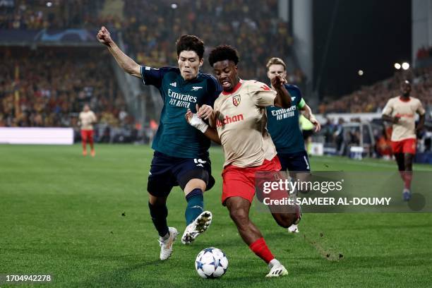 Lens' French forward Elye Wahi fights for the ball with Arsenal's Japanese defender Takehiro Tomiyasu during the UEFA Champions League Group B first...