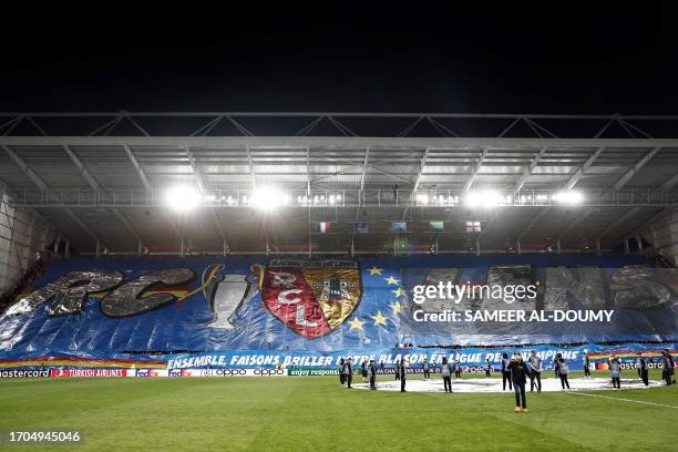 Lens supporters hold a tribune-lenght tifo for their club prior to the UEFA Champions League Group B first leg football match between RC Lens and...