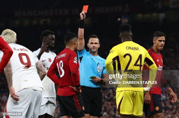 Referee Ivan Kruzliak shows a red card to Manchester United's Brazilian midfielder Casemiro during the UEFA Champions league group A football match...