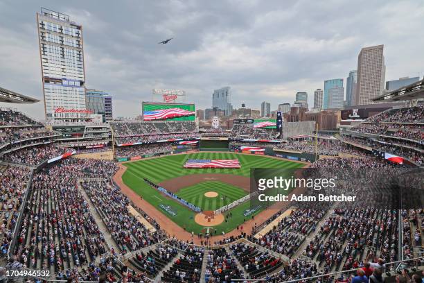 The Toronto Blue Jays and Minnesota Twins line up for the national anthems and a fly-over of a C-130 Hercules aircraft before Game One of the Wild...