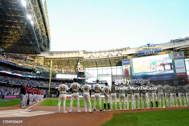 Members of the Milwaukee Brewers and the Arizona Diamondbacks stand on the field prior to Game 1 of the Wild Card Series between the Arizona...