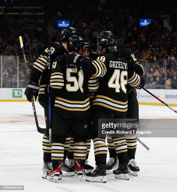 Matthew Poitras of the Boston Bruins celebrates his goal against the Washington Capitals with teammate Matt Grzelcyk, Brad Marchand and Derek Forbort...