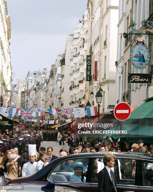 Queen Elizabeth II waves as she and Paris Mayor Bertrand Delanoe leave after a walkabout on the pedestrian Rue Montorgueil in Paris 06 April 2004, on...