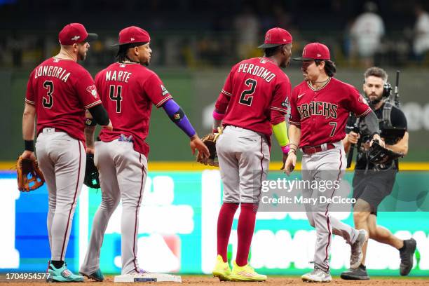 Evan Longoria, Ketel Marte, Geraldo Perdomo and Corbin Carroll of the Arizona Diamondbacks celebrate their win after Game 1 of the Wild Card Series...