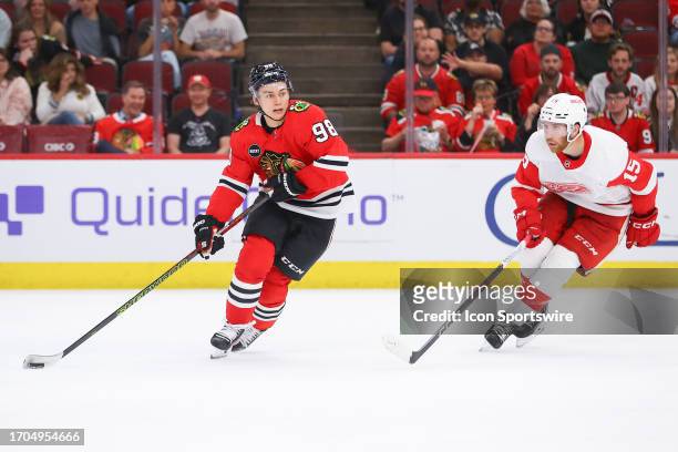 Chicago Blackhawks center Connor Bedard controls the puck against Detroit Red Wings Jared Mcisaac during a game between the Detroit Red Wings and the...