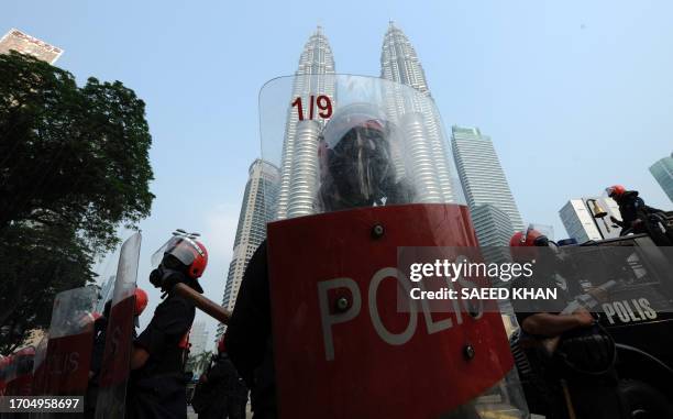 An anti-riot policeman stands ready with his shield to face protesters during a mass rally calling for electoral reform in Kuala Lumpur on July 9,...