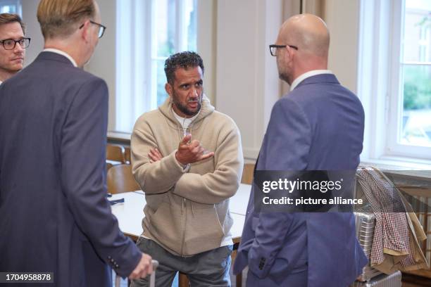 October 2023, Brandenburg, Brandenburg/Havel: Arafat Abou-Chaker stands surrounded by his lawyers in the Higher Regional Court during the...