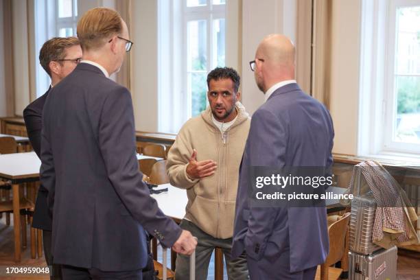 October 2023, Brandenburg, Brandenburg/Havel: Arafat Abou-Chaker stands surrounded by his lawyers in the Higher Regional Court during the...