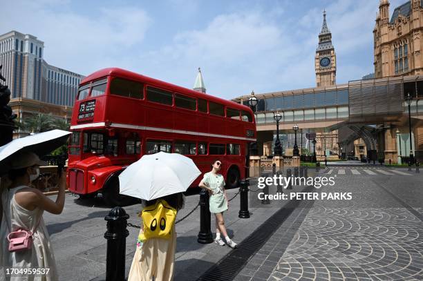 Chinese tourists take photos outside Macau's Londoner Casino on October 4, 2023 taking advantage of the country's week-long holiday at the start of...
