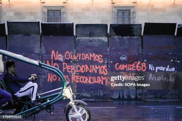 Grafitti is seen on a barricade at the National Palace during the 55th commemorative march of the Tlatelolco massacre. Protesters march to...