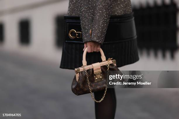 Sonia Lyson is seen wearing a wool mix coat with padded leather around the hemline and a golden XXL zipper from Louis Vuitton, a brown leather bag...