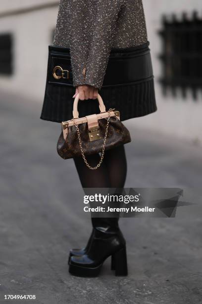 Sonia Lyson is seen wearing a wool mix coat with padded leather around the hemline and a golden XXL zipper from Louis Vuitton, a brown leather bag...