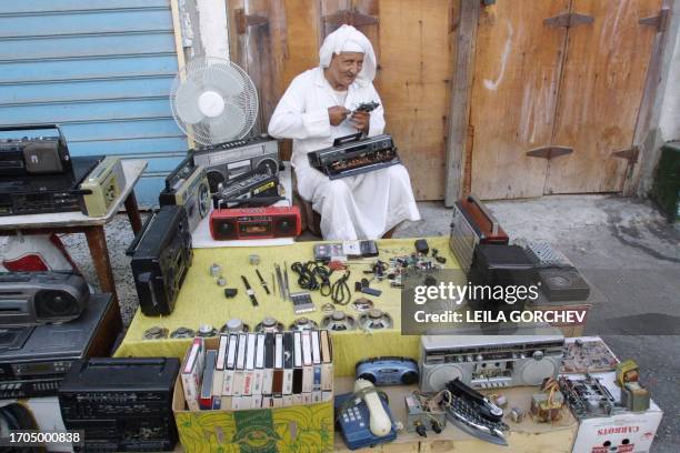 Bahraini man repairs a tape recorder 10 October 2001 in the old 'souk', or marketplace of Manama. AFP PHOTO/Leila GORCHEV