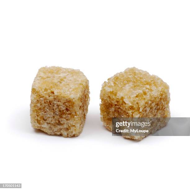 Two Brown Sugar Cubes On White Background.