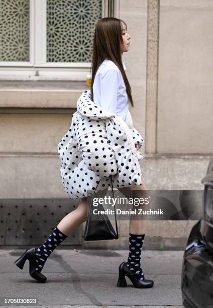 Guest is seen wearing a white shirt dress, polkadot puff Marni coat, black geometric Marni bag outside the Marni show during the Womenswear...