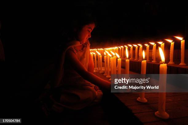 Portrait of a girl lighting candles at the Shahid minar on the eve of World Womens' Day . Dhaka, Bangladesh. December 8, 2005.