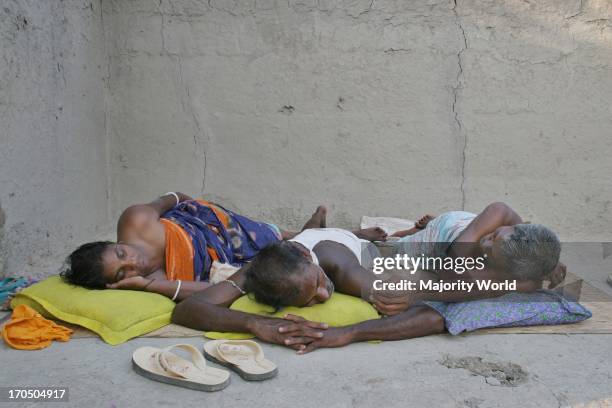 Family members of a Palanquin porters group passing their idle time. Palanquins are still used for carrying brides in remote Bangladesh. In Mathbari,...