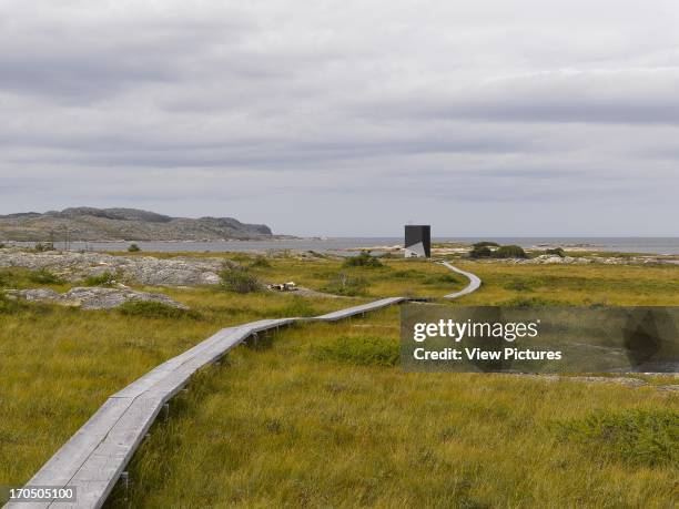 Distant view across marsh, with ribbon walkway, Tower Studio, Fogo Island, Canada, Architect: Todd Saunders, 2011.