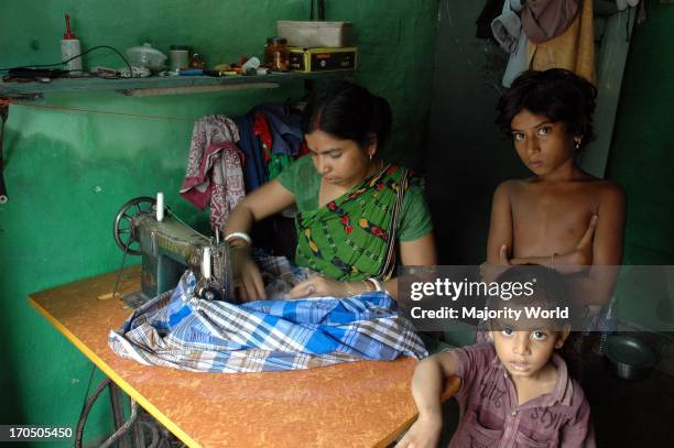 House wife sewing a lungi at a Road side slum of Kolkata city. Most of the transient roadside settlements and slums have been formed by refugees from...