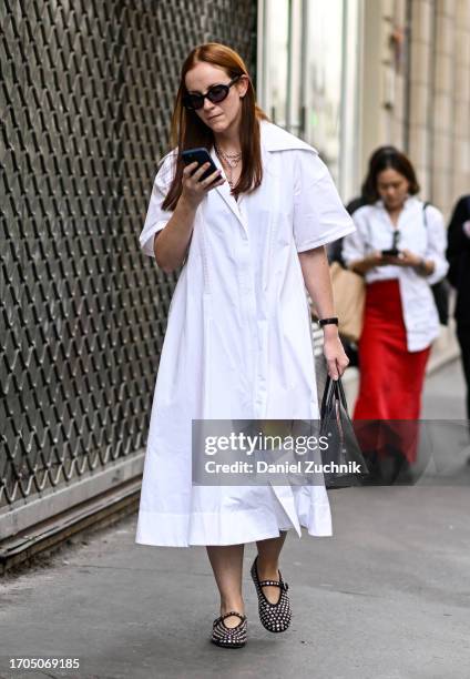 Guest is seen wearing a white shirt dress and studded shoes with black sunglasses and a black bag outside the Dries Van Noten show during the...