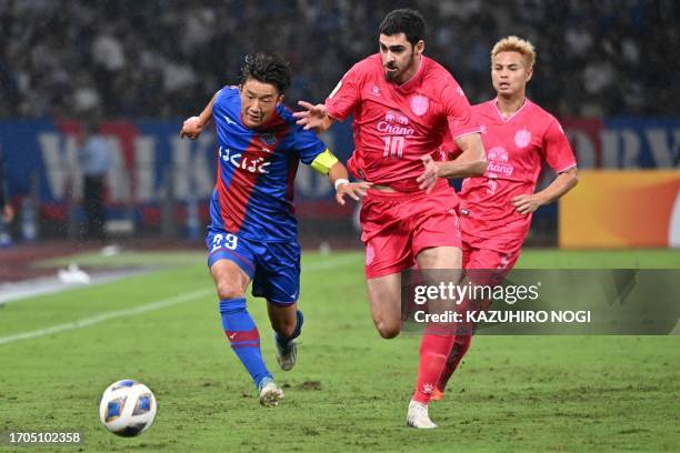 Japan's Ventforet Kofu Masahiro defender Masahiro Sekiguchi Sekiguchi and Thailand's Buriram United forward Ramil Sheydayev fight for the ball during...