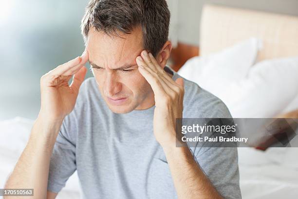 mann mit einem kopfschmerz reiben stirn - headache stock-fotos und bilder