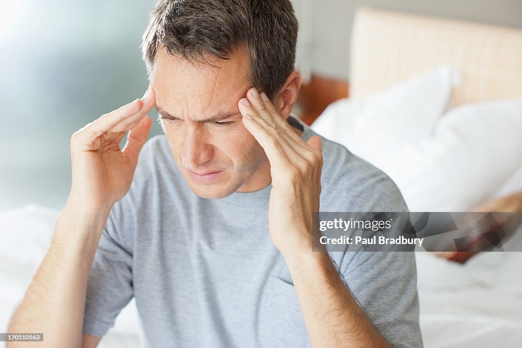 Man with headache rubbing forehead