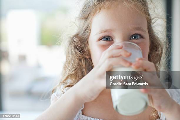 girl drinking glass of milk - childhood hunger stock pictures, royalty-free photos & images