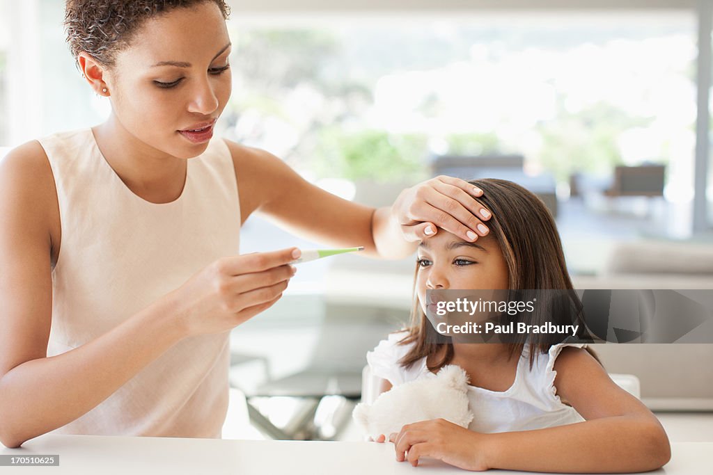 Mother taking daughters temperature