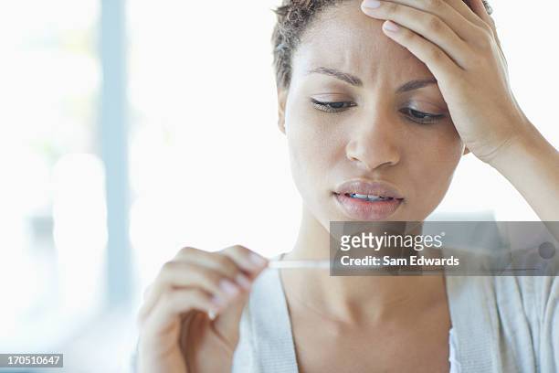 sick woman taking her temperature - fever chills stock pictures, royalty-free photos & images