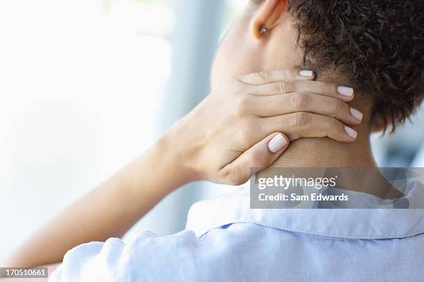 woman rubbing sore neck - menselijke nek stockfoto's en -beelden