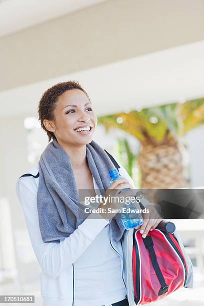 tired woman drinking water after playing tennis - duffle bag stock pictures, royalty-free photos & images
