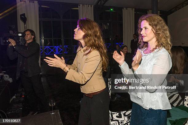 Gwendoline Hamon and Florence Darel listen to singer Melody Gardot as she performs during the Piaget Rose Day Event in Orangerie Ephemere at Jardin...